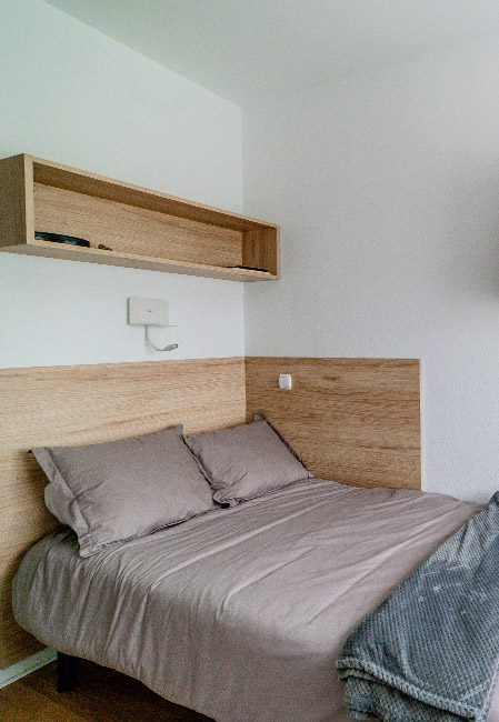 Detalle cama habitación individual cocina compartida residencia universitaria en Logroño